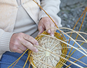 Someone in the middle of weaving a wicker basket 