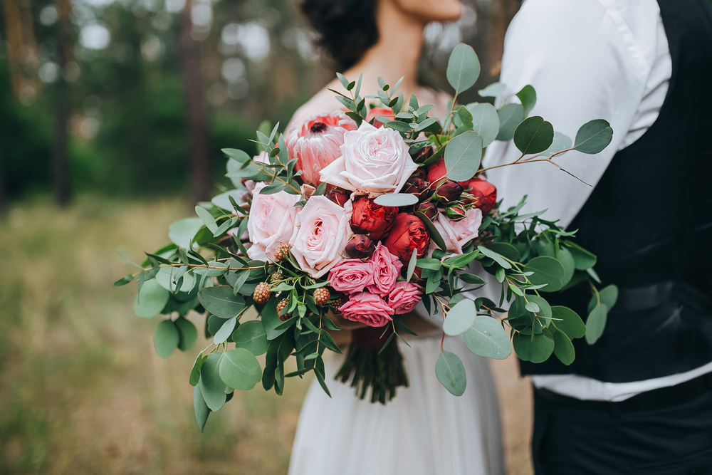 Bride and groom holding bouquet of flowers